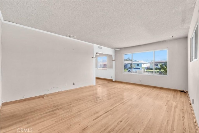 unfurnished living room featuring light wood-type flooring and a textured ceiling