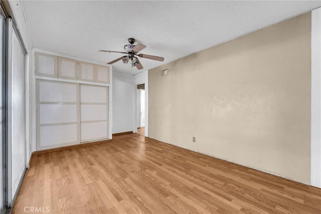 unfurnished bedroom featuring a textured ceiling, ceiling fan, and light wood-type flooring