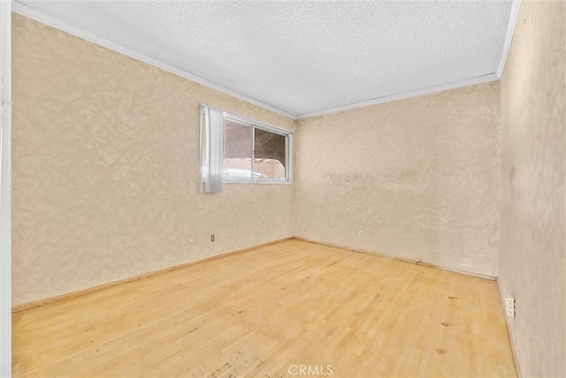 unfurnished room with a textured ceiling, crown molding, and hardwood / wood-style floors