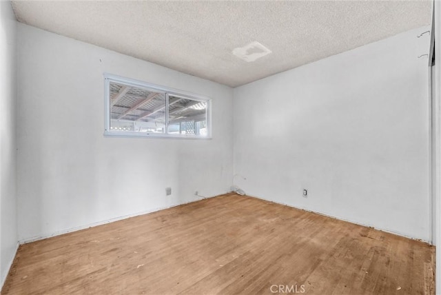 unfurnished room featuring a textured ceiling and wood-type flooring