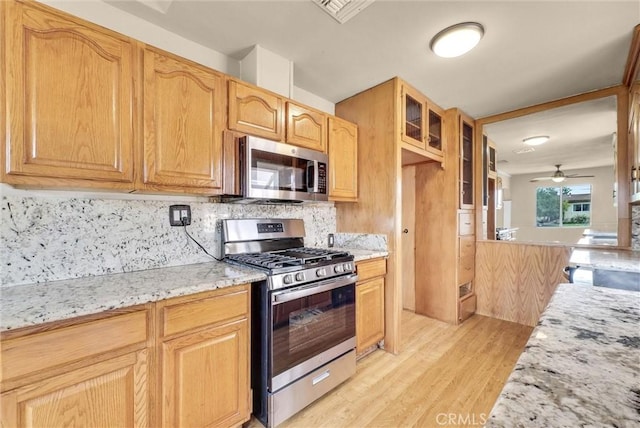 1307 N O Malley Ave, Covina, CA 91722 - kitchen featuring stainless steel appliances, light wood-style floors, tasteful backsplash, glass insert cabinets, and light stone countertops