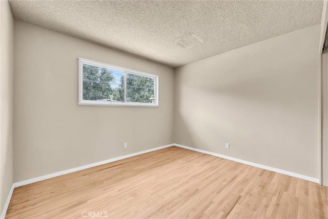 1307 N O Malley Ave, Covina, CA 91722 - spare room featuring light wood-style flooring, baseboards, and a textured ceiling