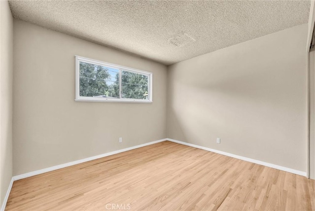 1307 N O Malley Ave, Covina, CA 91722 - empty room with light wood-style flooring and a textured ceiling
