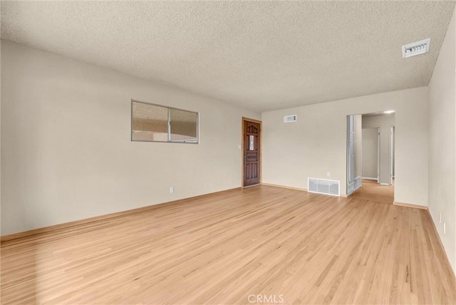 1307 N O Malley Ave, Covina, CA 91722 - empty room featuring light wood-style flooring, a textured ceiling, and baseboards
