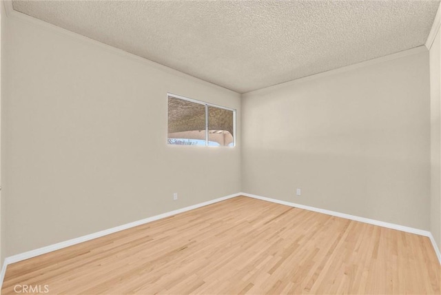 1307 N O Malley Ave, Covina, CA 91722 - empty room featuring a textured ceiling, wood finished floors, baseboards, and ornamental molding