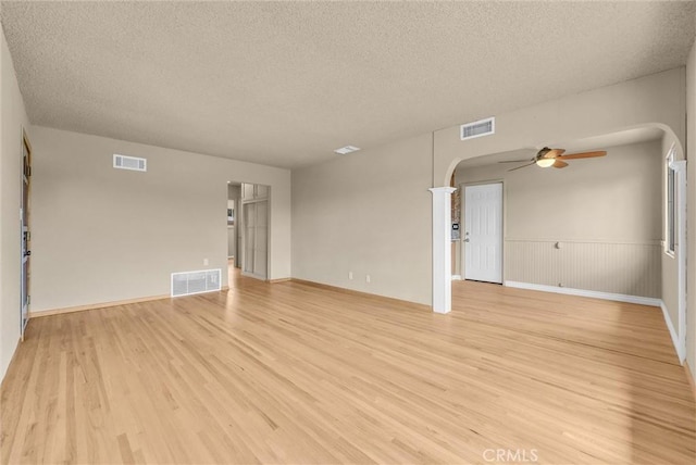 1307 N O Malley Ave, Covina, CA 91722 - empty room featuring arched walkways, light wood-type flooring, a textured ceiling, and ceiling fan