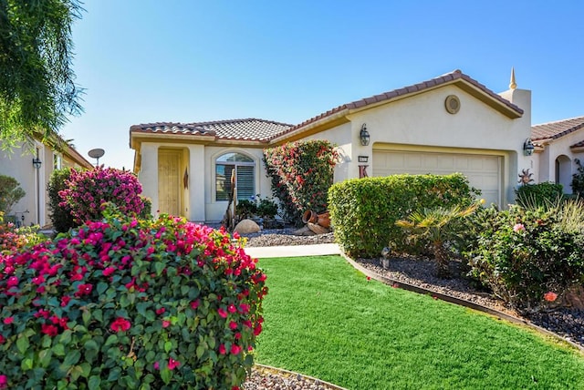 mediterranean / spanish home with a garage and a front lawn