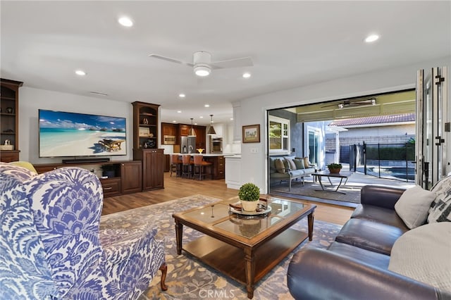 living room featuring ceiling fan and hardwood / wood-style flooring