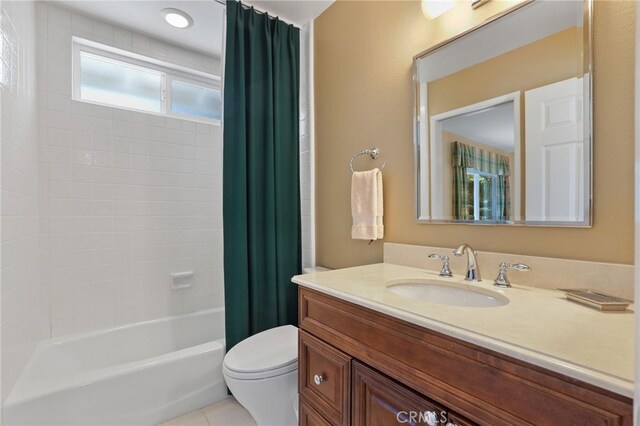 full bathroom featuring toilet, tile patterned floors, vanity, and shower / bath combo with shower curtain