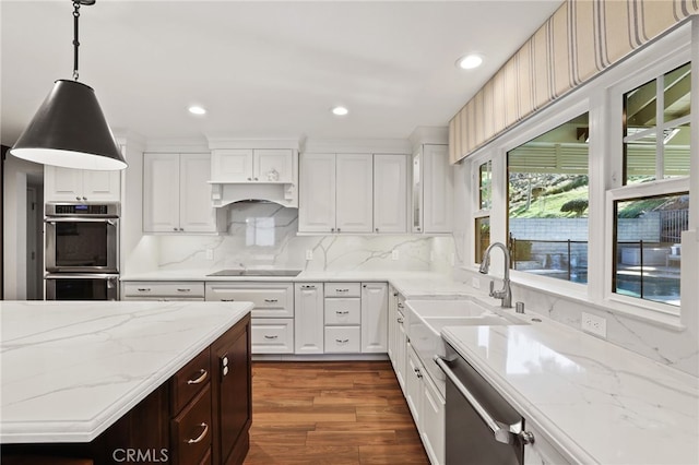 kitchen with white cabinets, stainless steel appliances, tasteful backsplash, sink, and hanging light fixtures