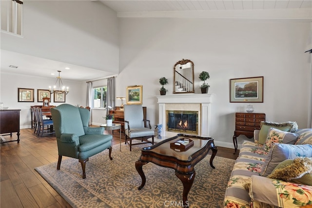 living room featuring beamed ceiling, wood-type flooring, and a notable chandelier