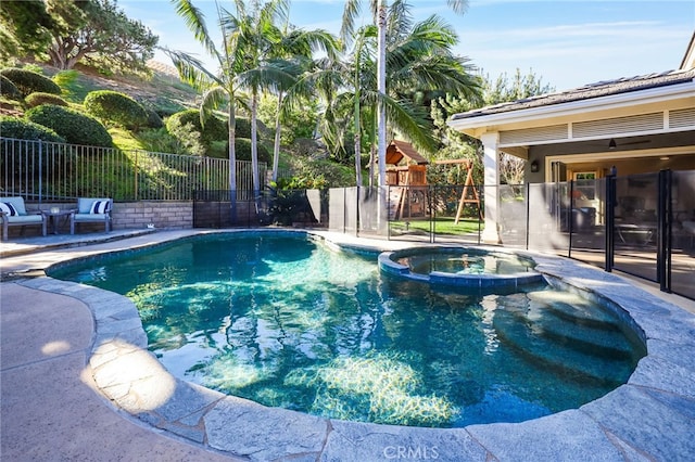 view of swimming pool featuring an in ground hot tub, a patio, and a playground