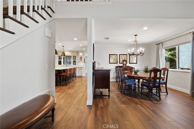 dining area featuring dark hardwood / wood-style floors, an inviting chandelier, and ornamental molding