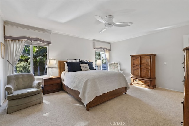 carpeted bedroom featuring ceiling fan and crown molding