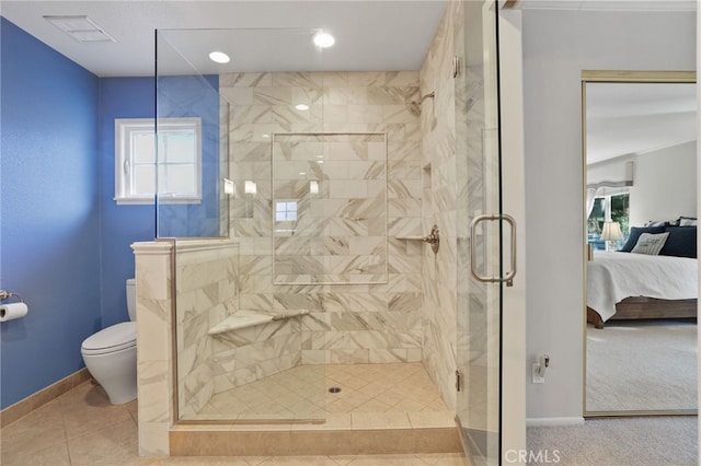 bathroom featuring toilet, plenty of natural light, and a shower with door