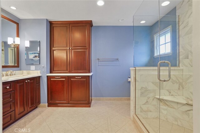 bathroom featuring a shower with shower door and vanity