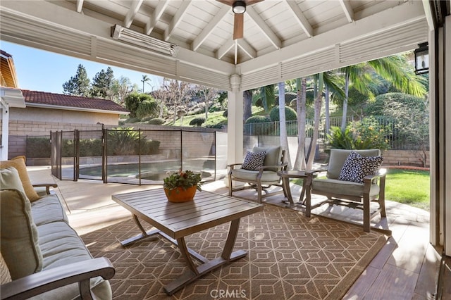 sunroom featuring ceiling fan, a healthy amount of sunlight, and lofted ceiling with beams