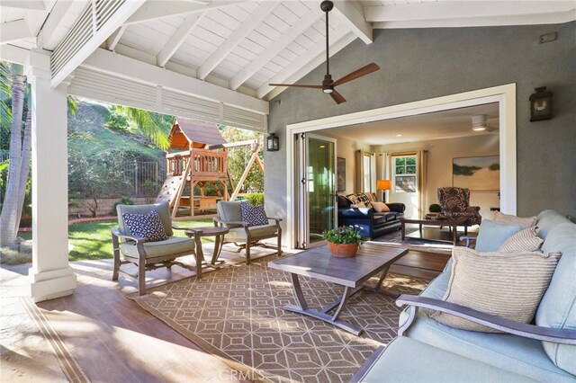 sunroom / solarium with ceiling fan, lofted ceiling with beams, and a healthy amount of sunlight