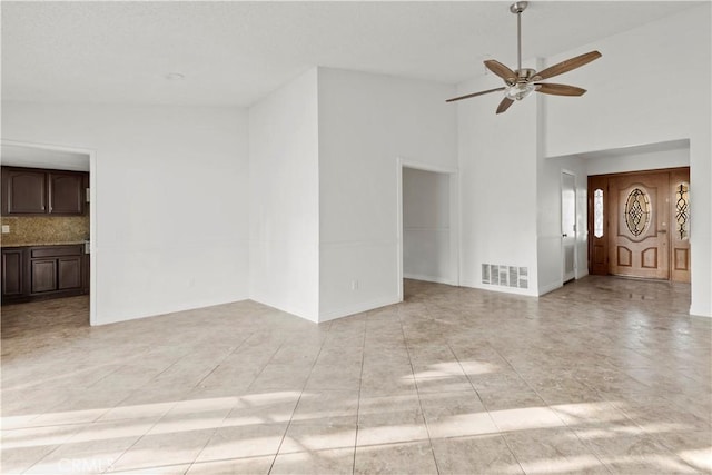 unfurnished living room featuring ceiling fan and high vaulted ceiling