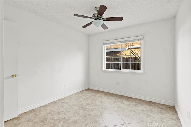 tiled empty room with ceiling fan and a textured ceiling