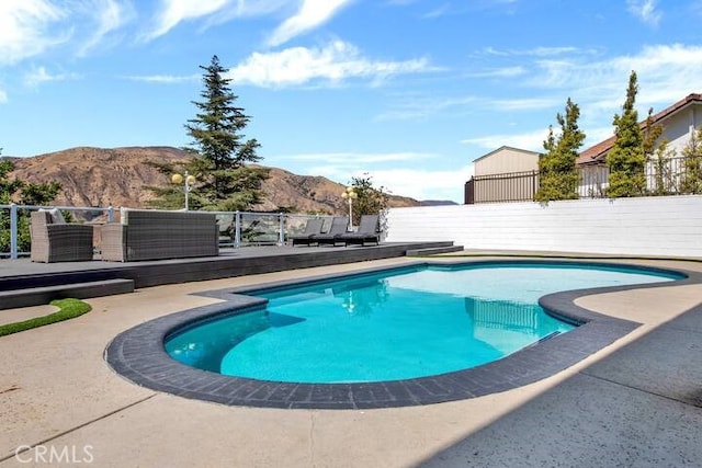 view of swimming pool with an outdoor hangout area, a mountain view, and a patio area