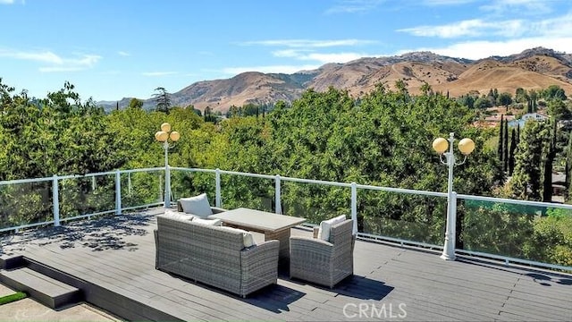 deck featuring outdoor lounge area and a mountain view