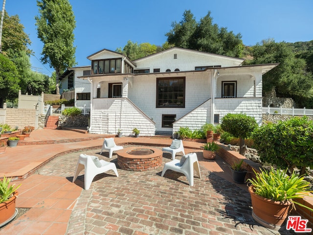 rear view of house featuring a patio area and a fire pit