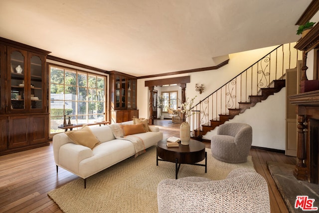 living room featuring plenty of natural light, hardwood / wood-style flooring, and crown molding