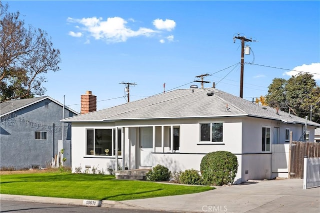 rear view of property featuring a lawn