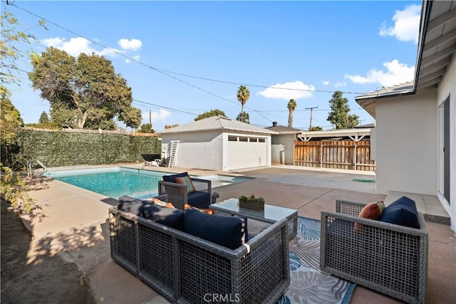 view of pool featuring a patio area, a garage, and an outdoor structure