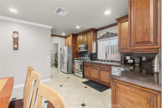 kitchen featuring stainless steel appliances, light tile patterned floors, backsplash, crown molding, and sink