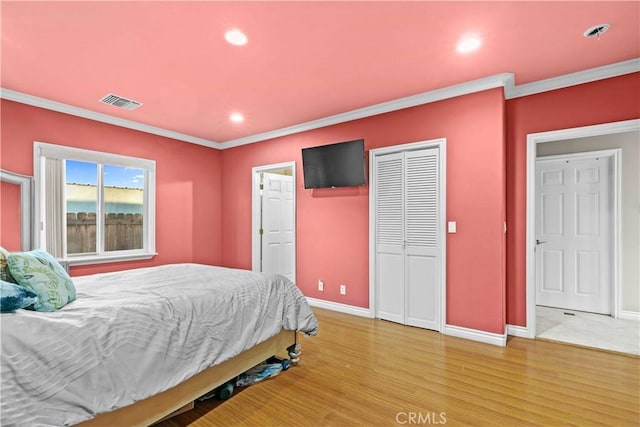 bedroom with ornamental molding and hardwood / wood-style flooring