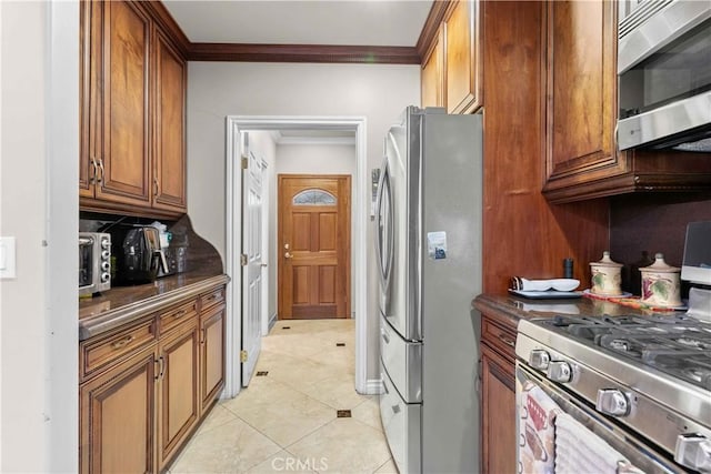 kitchen featuring light tile patterned floors, appliances with stainless steel finishes, and crown molding