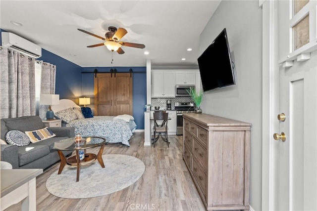 bedroom featuring light wood-type flooring, a wall mounted air conditioner, recessed lighting, and a barn door