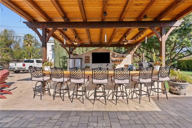 view of patio / terrace featuring ceiling fan and exterior bar