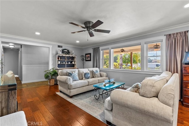 living area with a wainscoted wall, recessed lighting, wood finished floors, and crown molding