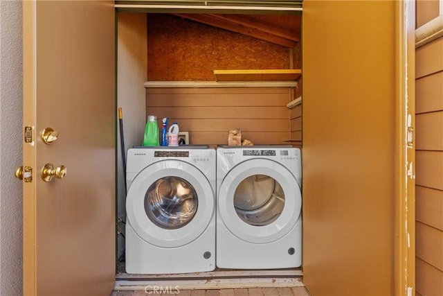 laundry area with washer and dryer, laundry area, and wood walls