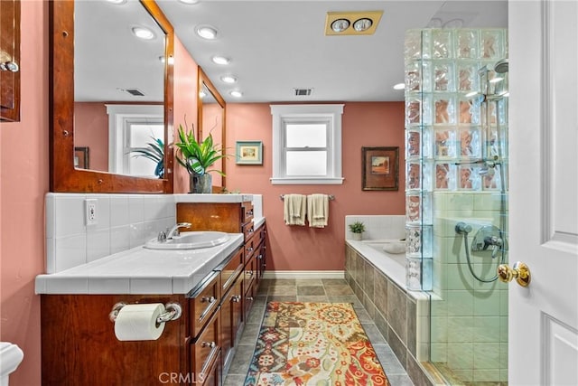 bathroom featuring a garden tub, backsplash, vanity, tiled shower, and baseboards