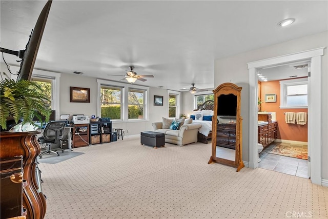 bedroom with a ceiling fan, light carpet, visible vents, and baseboards