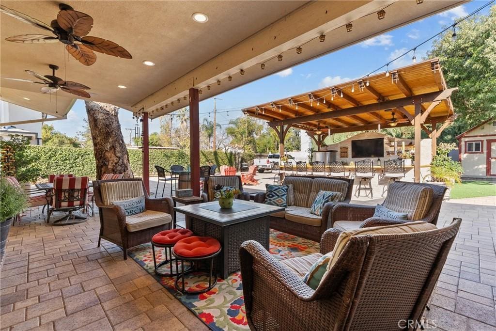 view of patio / terrace featuring outdoor lounge area, fence, and a ceiling fan