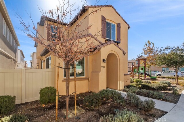 mediterranean / spanish-style house with a playground