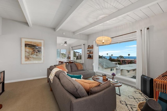 carpeted living room featuring ceiling fan with notable chandelier, beam ceiling, and a healthy amount of sunlight