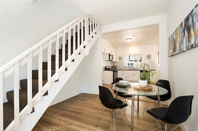 dining area featuring hardwood / wood-style flooring and sink