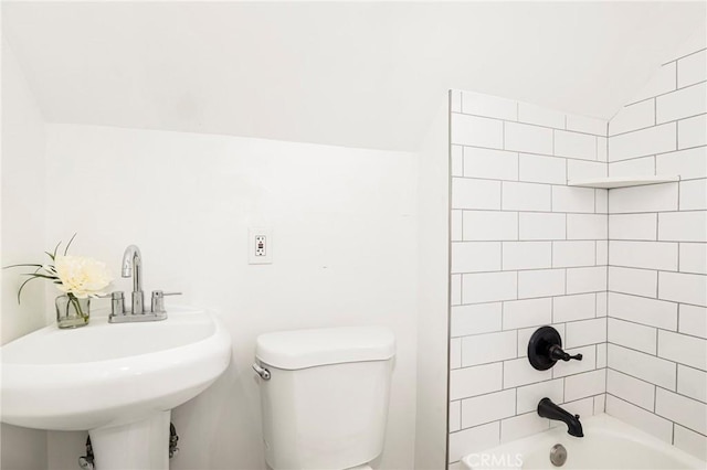 full bathroom with sink, lofted ceiling, tiled shower / bath combo, and toilet