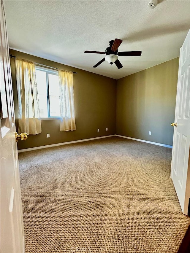 spare room featuring a textured ceiling, carpet floors, and ceiling fan