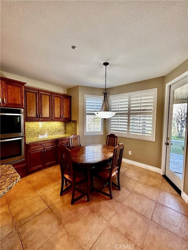 dining room featuring a textured ceiling and light tile patterned floors