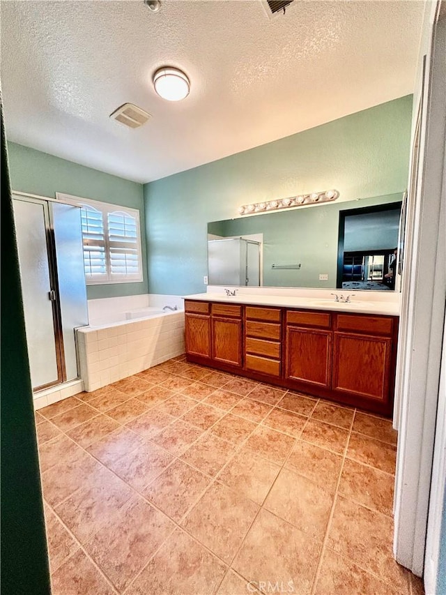 bathroom with tile patterned flooring, a textured ceiling, shower with separate bathtub, and vanity