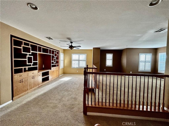 interior space featuring a textured ceiling and carpet floors