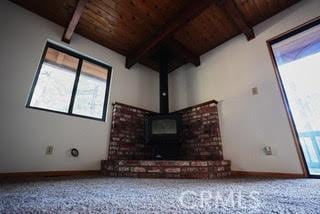 unfurnished living room with carpet floors, wooden ceiling, and a wealth of natural light