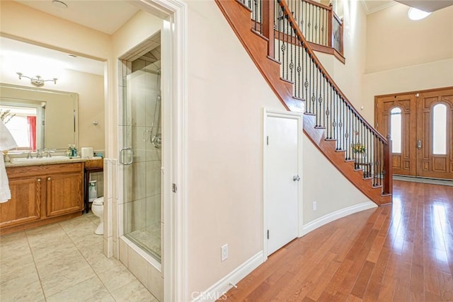 entrance foyer featuring sink, light hardwood / wood-style floors, and a high ceiling